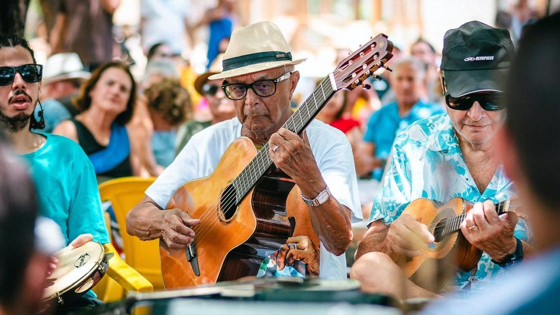 Roda de choro ao ar livre, com músicos e público reunidos