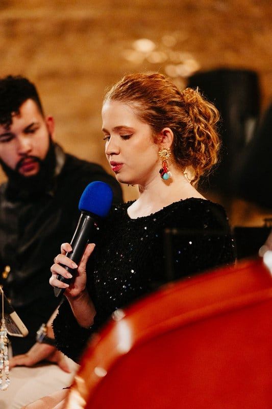Cantora em apresentação ao lado de músicos