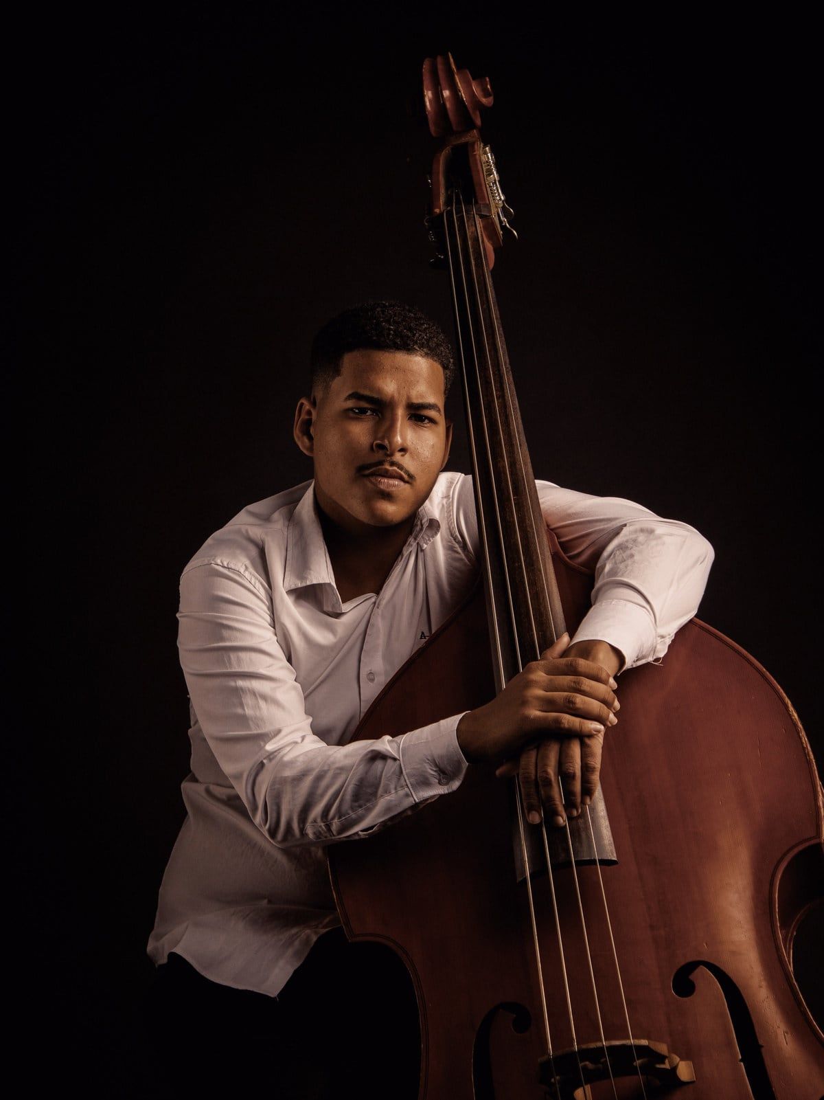 Luiz Guilherme abraçado ao contrabaixo acústico