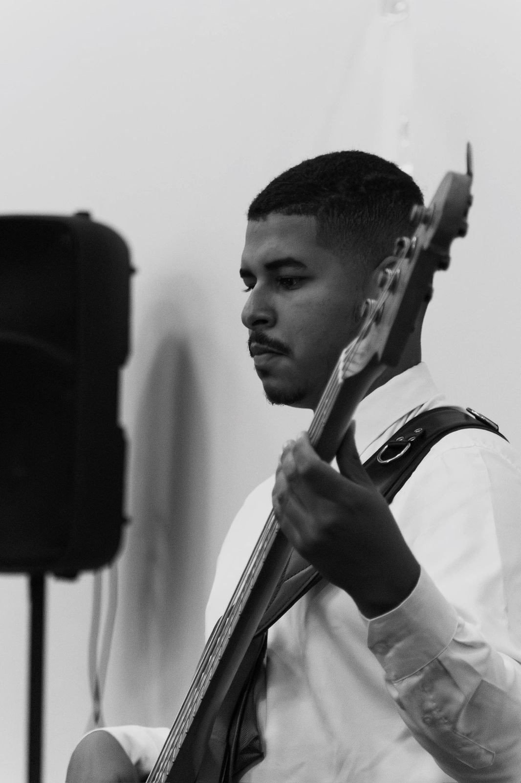 Luiz Guilherme tocando baixo, em preto e branco