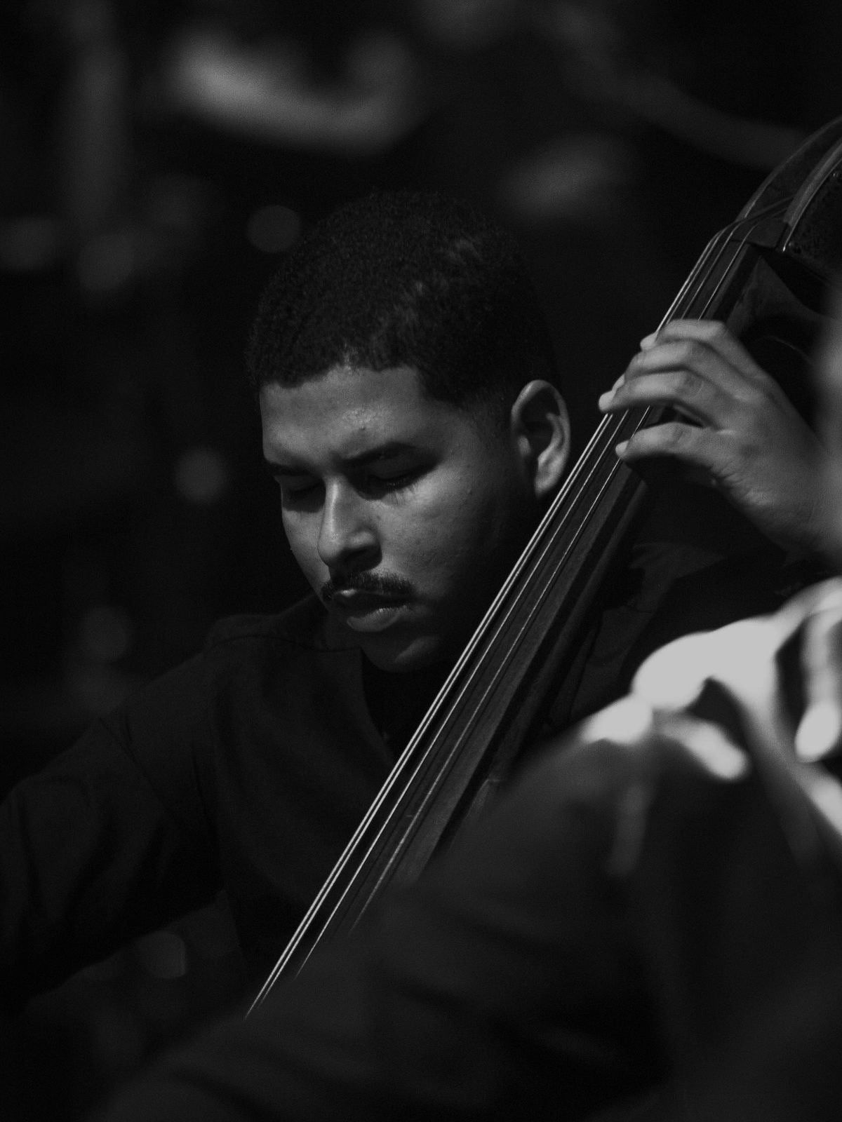 Retrato em preto e branco de Luiz Guilherme tocando contrabaixo